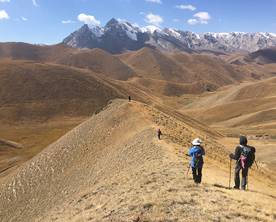 hikers traversing a mountain ridge with stunning peaks and valleys in the background showcasing nature's beauty and an adventure for six outdoors enthusiasts
