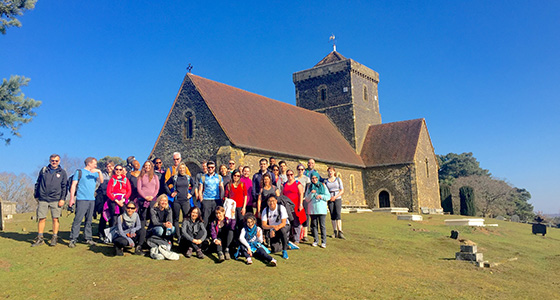 group of people standing in front of a church on a sunny day with clear blue sky representing community and outdoor activities two events