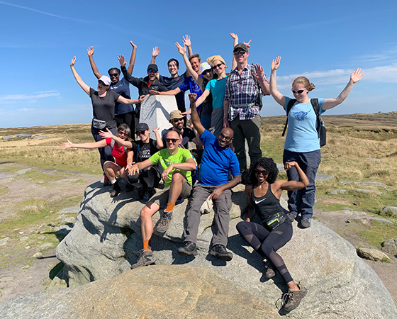 group of diverse people celebrating on a rock in a sunny outdoor setting enjoying nature and fresh air 4 adventure seekers